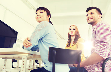 Image showing happy creative team drinking coffee at office