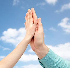 Image showing father and child hands making high five over sky