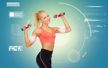 Image showing happy young sporty woman exercising with dumbbells