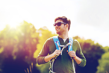 Image showing happy young man with backpack hiking outdoors