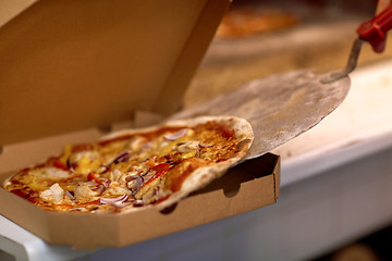 Image showing chef placing pizza from peel to box at pizzeria