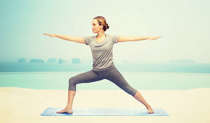 Image showing woman making yoga warrior pose on mat