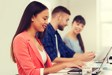 Image showing happy african woman over creative team at office