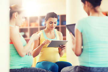 Image showing happy pregnant women with gadgets in gym