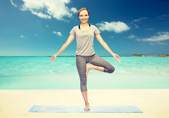 Image showing woman making yoga in tree pose on mat