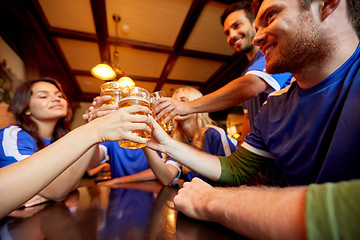 Image showing football fans clinking beer glasses at sport bar