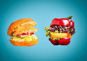 Image showing The healthy sandwich with fresh pepper, onion, salad lettuce and unhealthy harmful hamburger