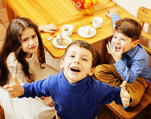 Image showing little cute boys eating dessert on wooden kitchen. home interior