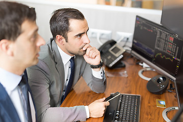 Image showing Stock brokers looking at computer screens, trading online.