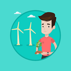 Image showing Worker of wind farm holding green small plant.