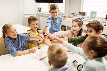 Image showing happy children holding hands at robotics school