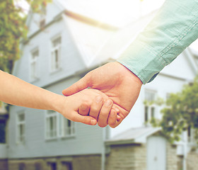 Image showing father and child holding hands over house