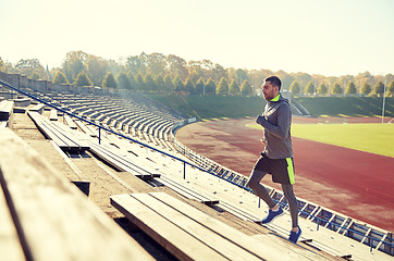 Image showing happy young man running upstairs on stadium