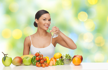 Image showing happy woman with glass of water and healthy food