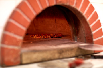 Image showing pizza baking in oven at pizzeria