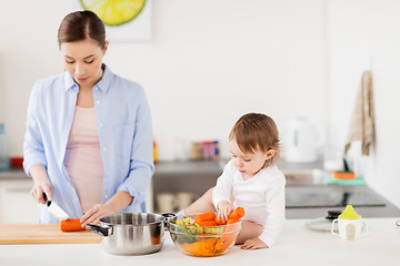 Image showing happy mother and baby cooking food at home kitchen