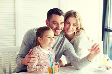 Image showing happy family taking selfie at restaurant