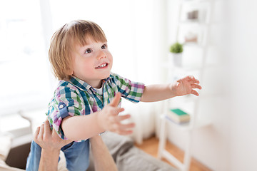 Image showing father hands holding happy little boy at home