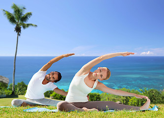 Image showing happy couple making yoga exercises outdoors