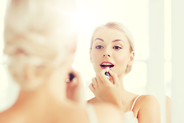 Image showing woman with lipstick applying make up at bathroom