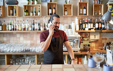 Image showing happy man or waiter at bar calling on smartphone