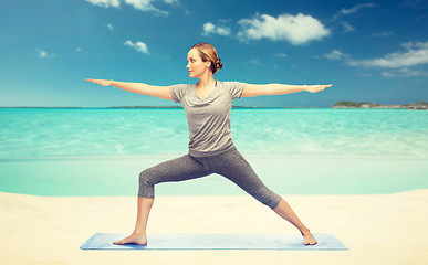 Image showing woman making yoga warrior pose on mat