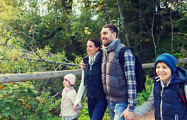 Image showing happy family with backpacks hiking in woods