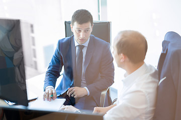 Image showing Two businessmen discussing a bisiness problem at meeting in trading office.