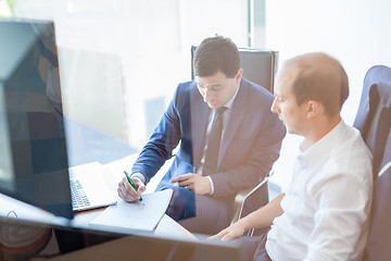 Image showing Two businessmen discussing a bisiness problem at meeting in trading office.