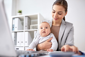 Image showing happy businesswoman with baby and laptop at office