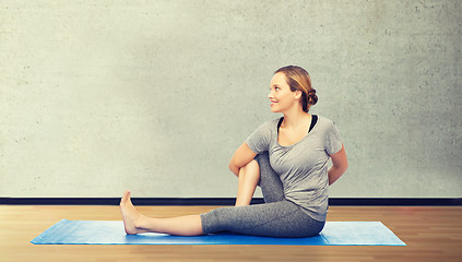 Image showing woman making yoga in twist pose on mat