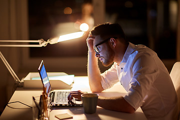 Image showing businessman typing on laptop at night office