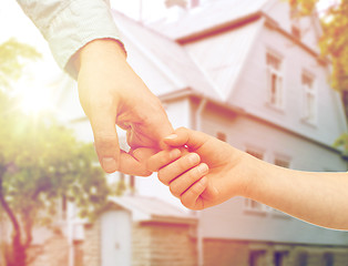 Image showing father and child holding hands over house