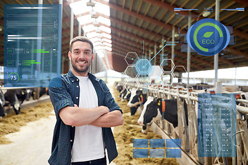 Image showing man or farmer with cows in cowshed on dairy farm