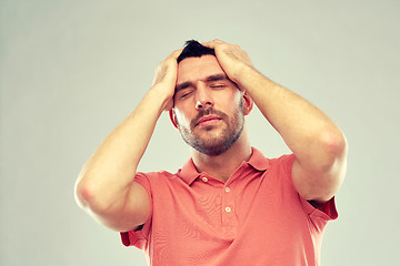 Image showing unhappy man suffering from head ache