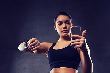 Image showing woman with heart-rate watch and smartphone in gym