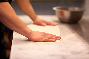 Image showing chef hands preparing dough on table at kitchen