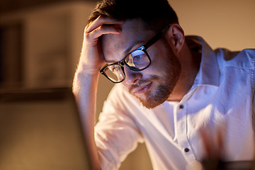 Image showing businessman with laptop thinking at night office