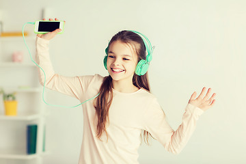 Image showing girl with smartphone and headphones at home