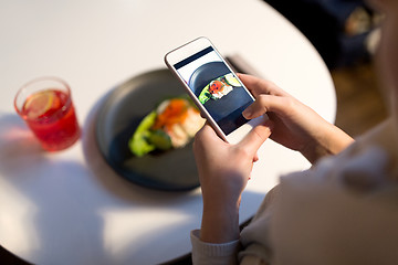 Image showing woman with smartphone photographing food at cafe