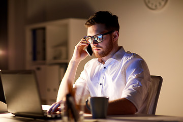 Image showing businessman calling on smartphone at night office