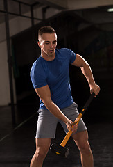 Image showing man workout with hammer and tractor tire