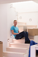 Image showing young man sitting in stairway at home
