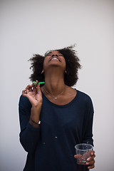 Image showing black woman in party hat blowing in whistle