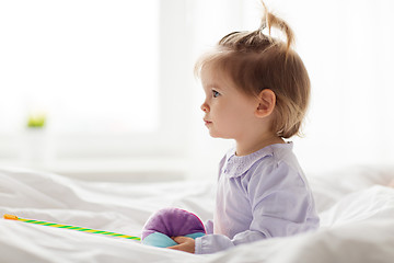 Image showing lovely little girl with toys in bed at home