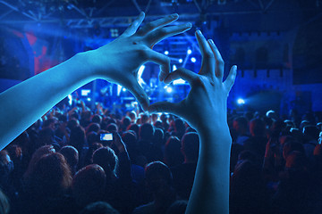Image showing The silhouettes of concert crowd in front of bright stage lights
