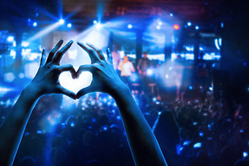 Image showing The silhouettes of concert crowd in front of bright stage lights