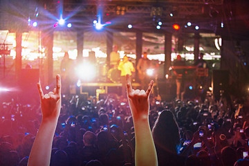 Image showing The silhouettes of concert crowd in front of bright stage lights