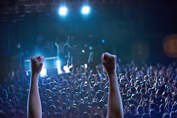 Image showing The silhouettes of concert crowd in front of bright stage lights