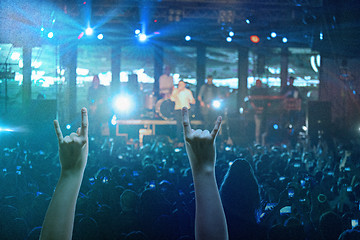 Image showing The silhouettes of concert crowd in front of bright stage lights